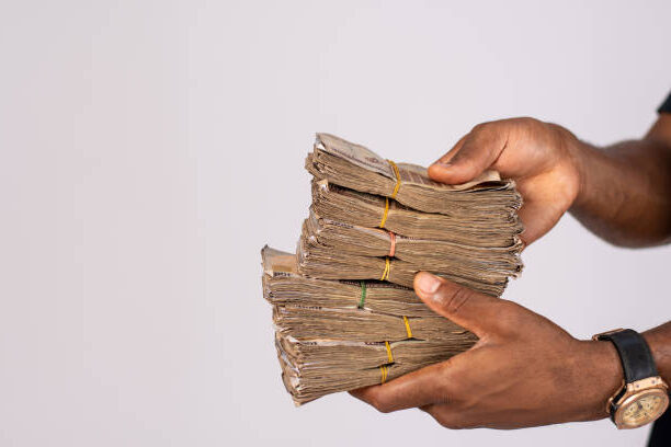 The african black man holding a pack of Naira Nigerian currency money